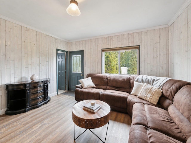 living room featuring wood finished floors, baseboards, and ornamental molding