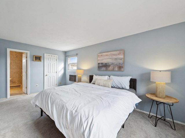 bedroom featuring a baseboard heating unit, baseboards, carpet, and ensuite bath