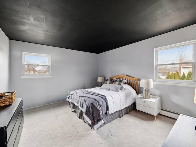 carpeted bedroom with baseboard heating and multiple windows