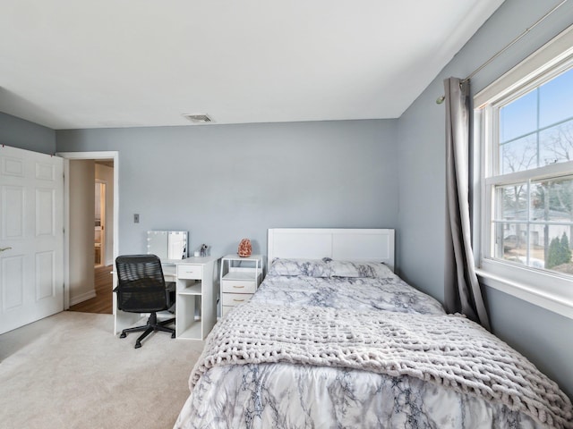 bedroom featuring visible vents and light carpet