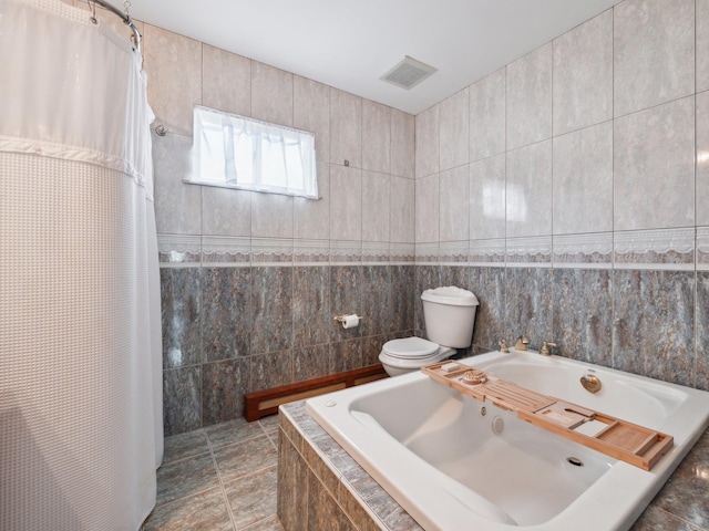 full bath featuring visible vents, toilet, a garden tub, a tile shower, and tile walls