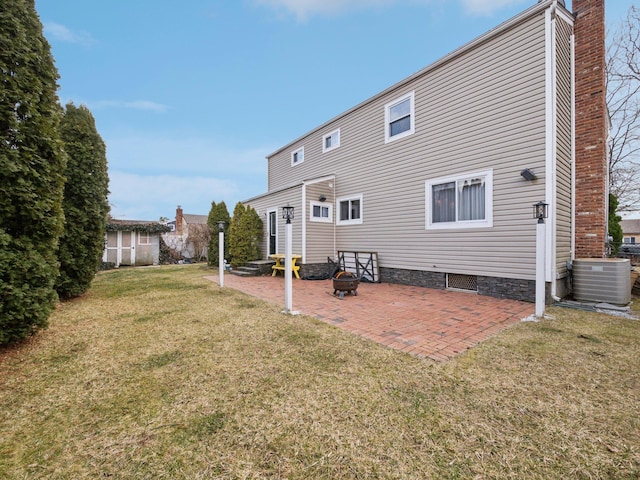 rear view of house with a yard, a patio area, cooling unit, and a chimney