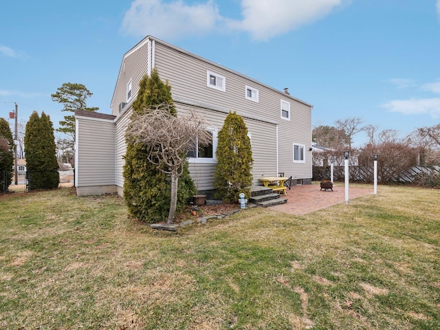 back of house featuring a patio area, a lawn, and fence