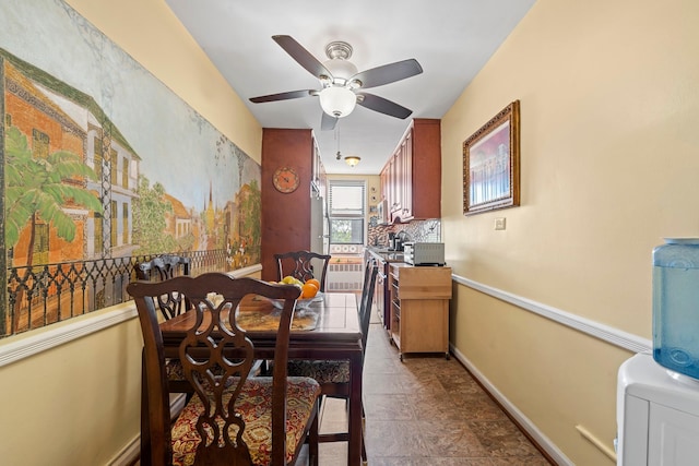 dining space with baseboards and ceiling fan