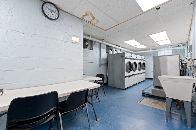 interior space featuring tile patterned floors, a paneled ceiling, and washer / clothes dryer