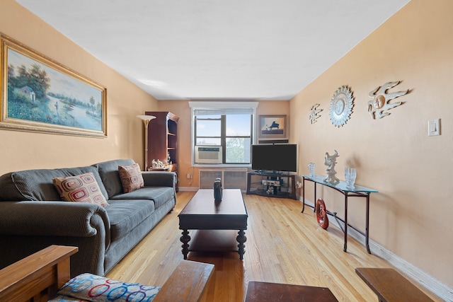 living area featuring light wood-style flooring, cooling unit, radiator heating unit, and baseboards