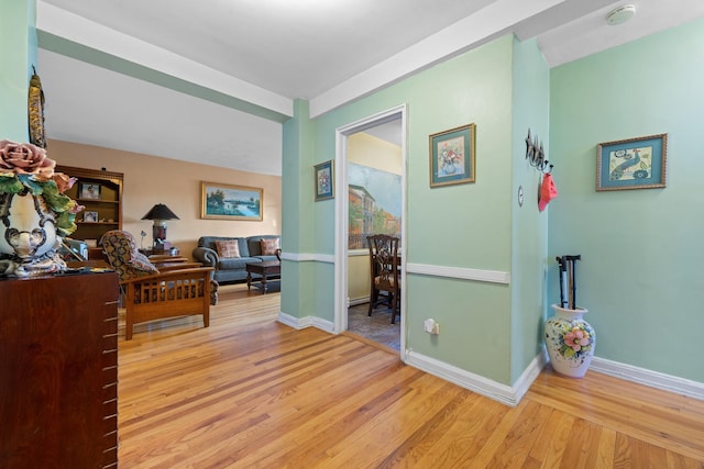 corridor with wood finished floors and baseboards