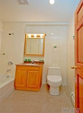 bathroom featuring visible vents, tub / shower combination, toilet, vanity, and a baseboard radiator