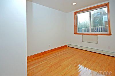 spare room with recessed lighting, a baseboard radiator, and wood finished floors