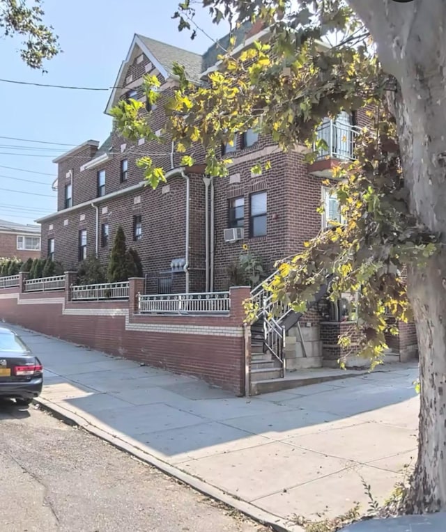 view of front of home featuring brick siding and fence