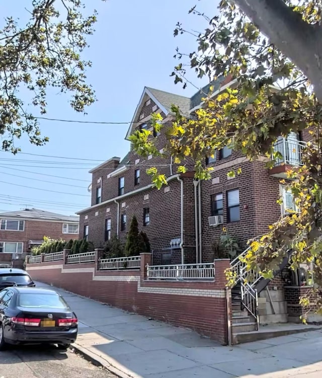 view of front of property with brick siding and fence