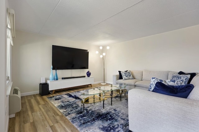 living room with baseboards, a textured ceiling, and wood finished floors