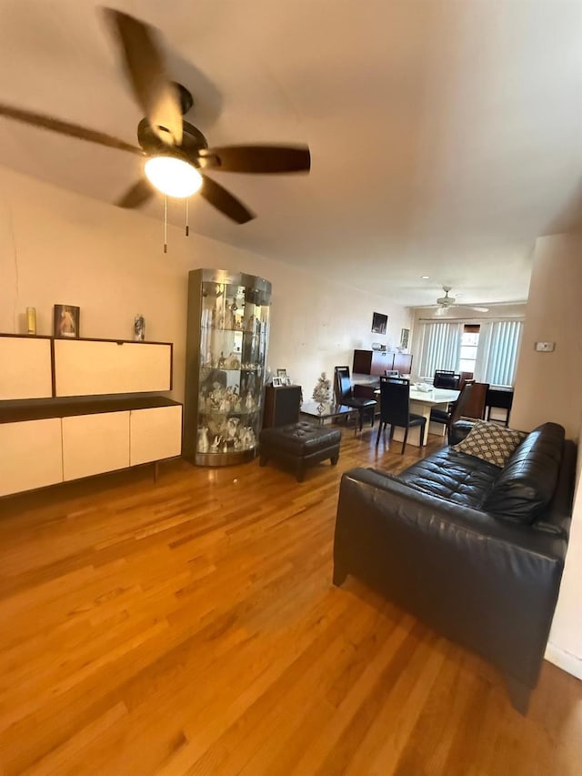 living room featuring wood finished floors and a ceiling fan