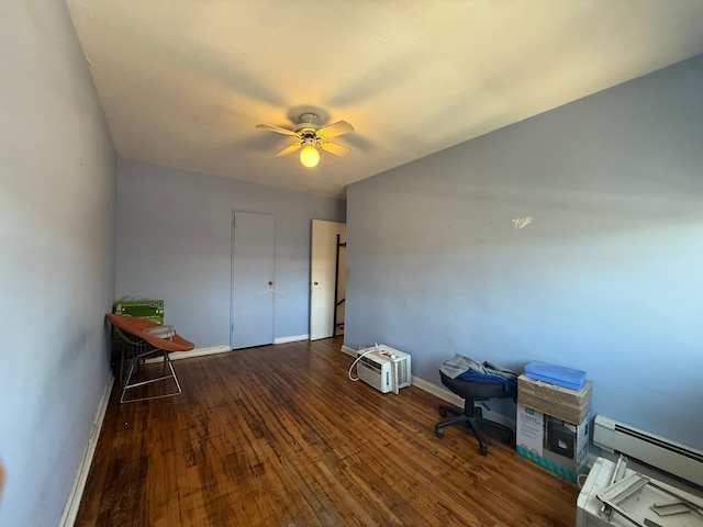 unfurnished office with a ceiling fan, wood finished floors, baseboards, and a baseboard radiator