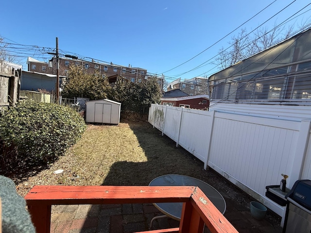 view of yard with an outbuilding, a storage shed, and a fenced backyard