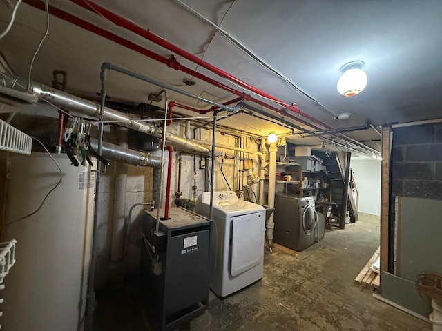 unfinished basement with gas water heater, a heating unit, and washing machine and clothes dryer