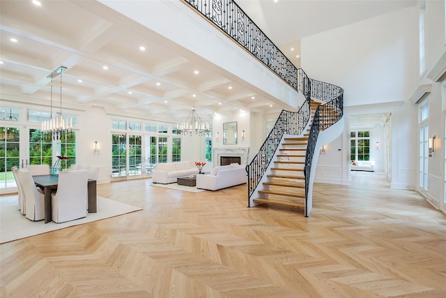 unfurnished living room featuring a chandelier, recessed lighting, stairs, and a high ceiling