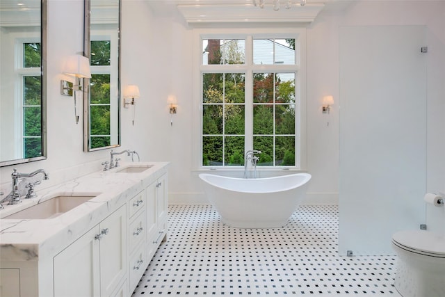 full bath with double vanity, a soaking tub, toilet, and a sink