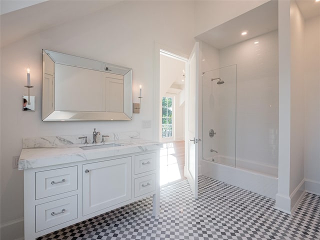 bathroom featuring vanity, shower / tub combination, and lofted ceiling