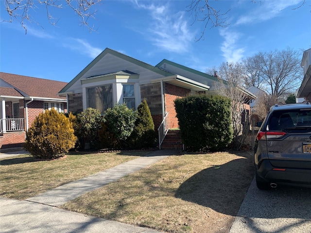 view of front facade featuring brick siding and a front yard