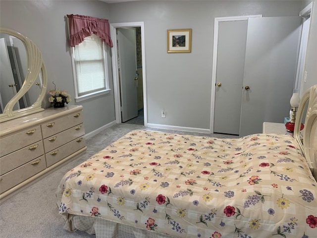 bedroom featuring light colored carpet and baseboards