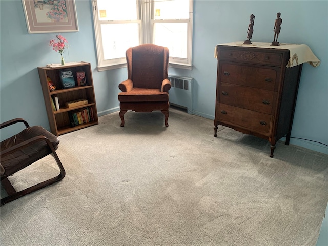 sitting room with carpet flooring, baseboards, and radiator heating unit