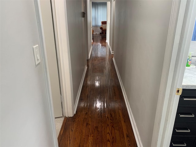 corridor with baseboards and dark wood-style flooring