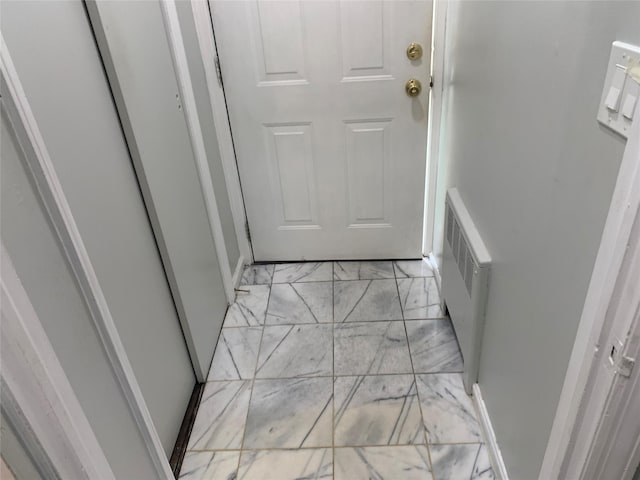 doorway with radiator and marble finish floor