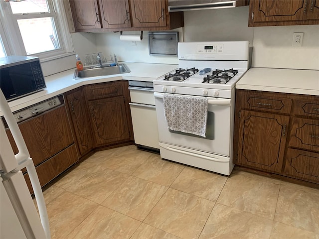 kitchen with ventilation hood, gas range gas stove, a sink, light countertops, and dishwasher