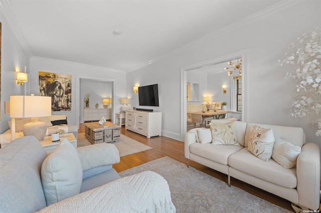 living area featuring baseboards, wood finished floors, and crown molding