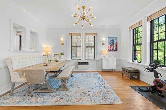 dining room featuring a chandelier, radiator heating unit, ornamental molding, wood finished floors, and plenty of natural light