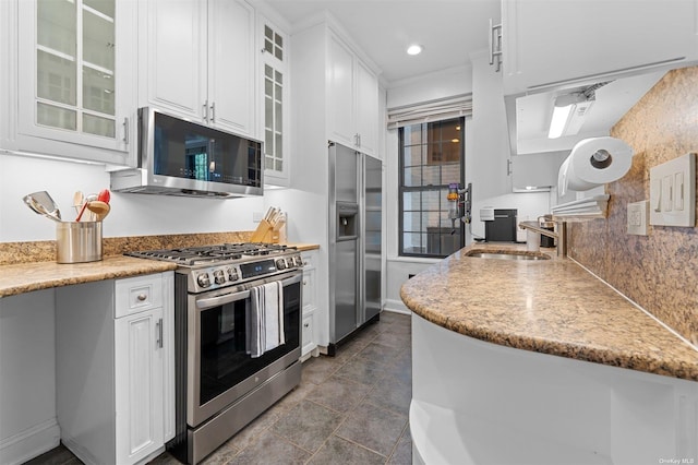 kitchen featuring a sink, white cabinets, glass insert cabinets, and stainless steel appliances