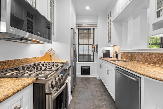 kitchen with white cabinetry, glass insert cabinets, tasteful backsplash, and stainless steel appliances