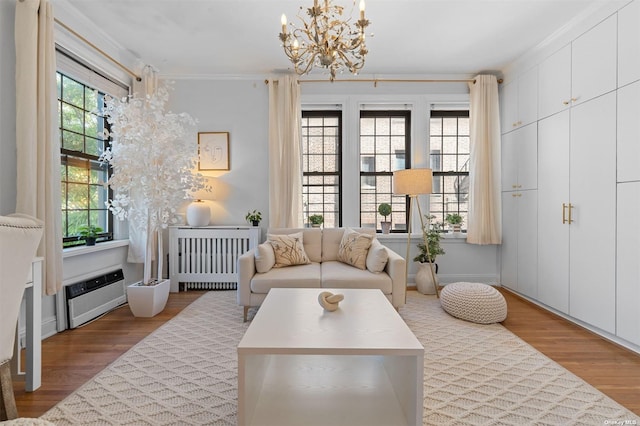 sitting room featuring plenty of natural light, wood finished floors, and crown molding