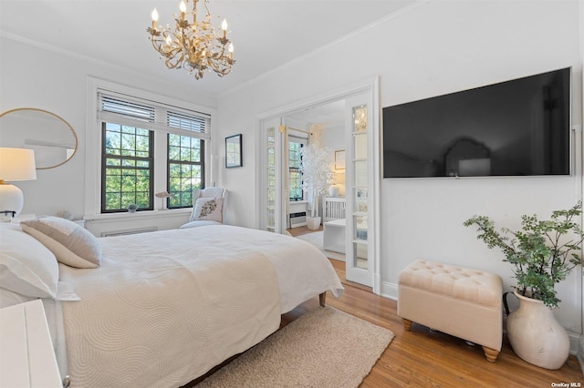 bedroom featuring baseboards, a notable chandelier, wood finished floors, and crown molding