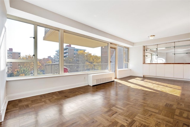 spare room featuring radiator and baseboards