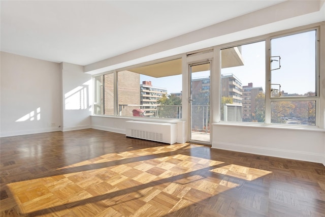 interior space featuring a city view, radiator heating unit, and baseboards