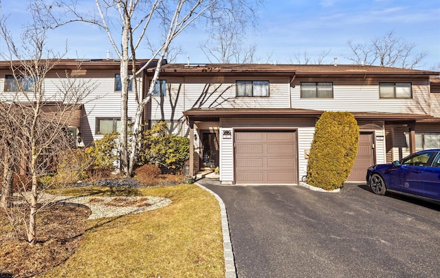 view of property featuring aphalt driveway and a garage