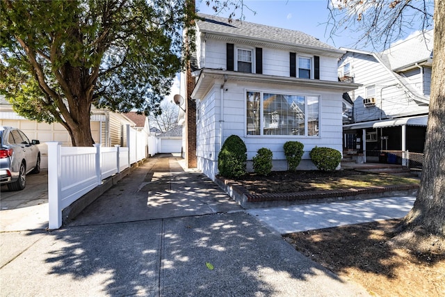 american foursquare style home with an outbuilding and fence