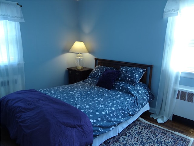 bedroom with radiator and wood finished floors