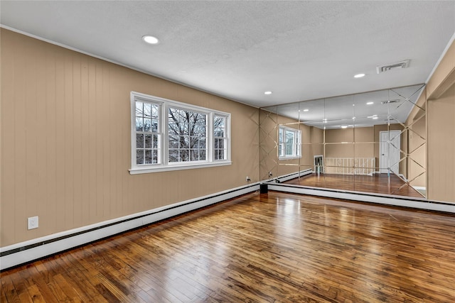 recreation room with hardwood / wood-style flooring, recessed lighting, visible vents, and a textured ceiling