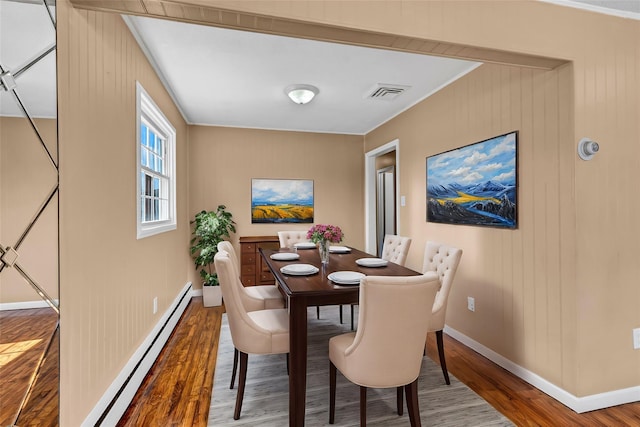 dining area featuring visible vents, baseboards, baseboard heating, and wood finished floors