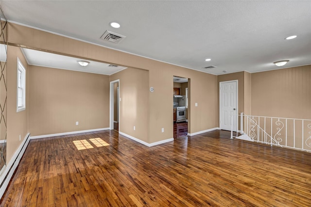 unfurnished room with a baseboard heating unit, visible vents, and wood-type flooring