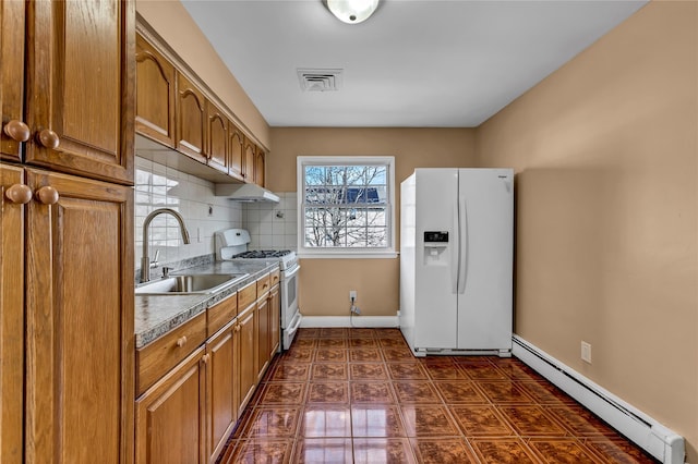 kitchen featuring tasteful backsplash, visible vents, a baseboard radiator, white appliances, and a sink