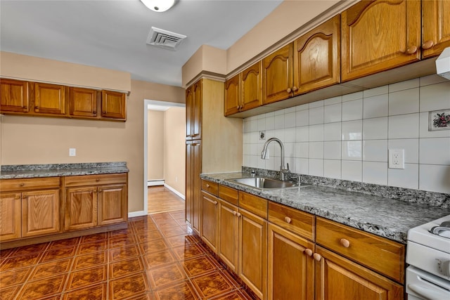 kitchen featuring brown cabinets and a sink