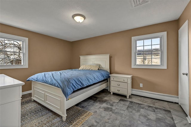 bedroom featuring visible vents, baseboards, and a baseboard radiator