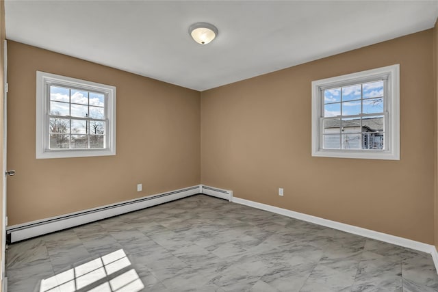 empty room featuring marble finish floor, a baseboard heating unit, and baseboards