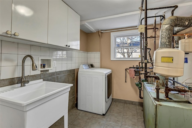 laundry area featuring tile walls, light tile patterned flooring, cabinet space, washer / clothes dryer, and a sink