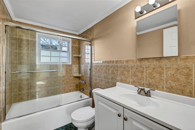 full bathroom featuring vanity, shower / bath combination with glass door, ornamental molding, tile walls, and toilet