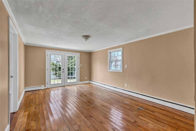 empty room featuring crown molding, a baseboard heating unit, a baseboard radiator, french doors, and wood-type flooring